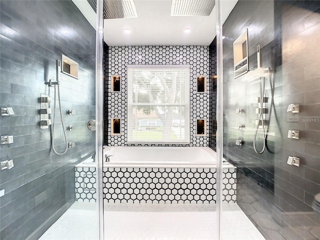 bathroom with tile patterned flooring, separate shower and tub, and tile walls