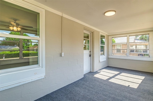 unfurnished sunroom with ceiling fan