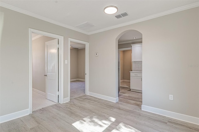 spare room featuring ornamental molding and light hardwood / wood-style flooring