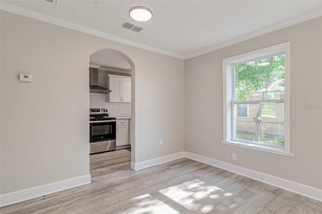 interior space with tasteful backsplash, stainless steel range with electric stovetop, wall chimney range hood, light hardwood / wood-style flooring, and white cabinets