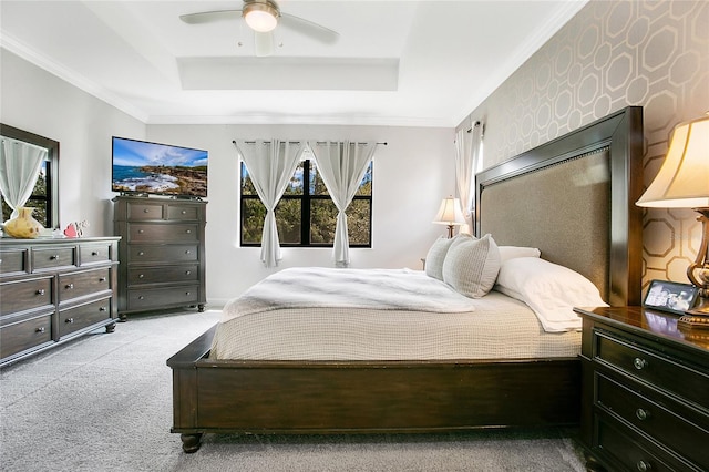 bedroom featuring a raised ceiling, multiple windows, ceiling fan, and light colored carpet