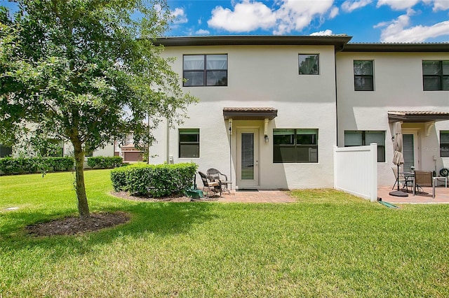 rear view of property with a lawn and a patio