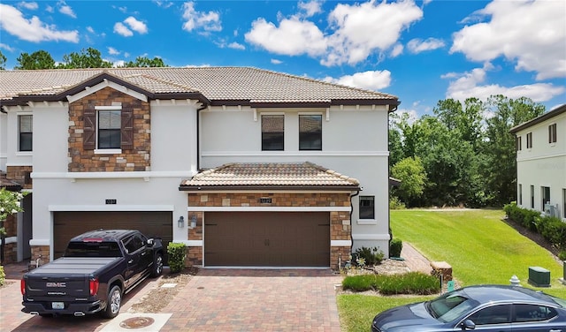 mediterranean / spanish house featuring central air condition unit, a front lawn, and a garage