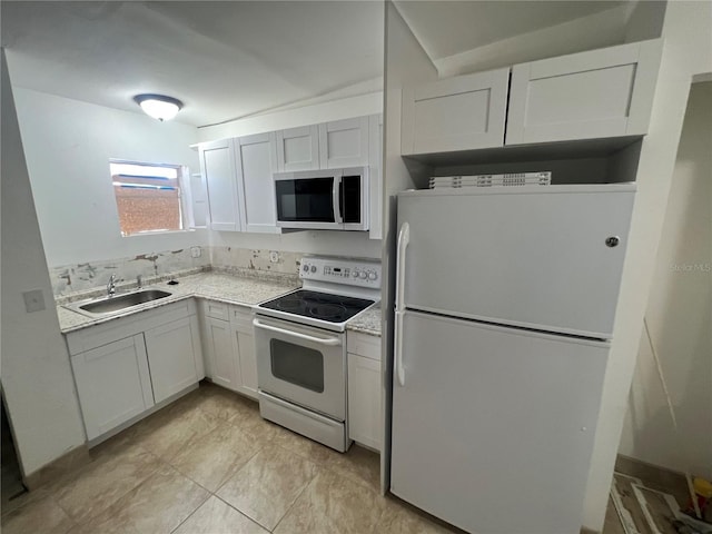 kitchen featuring white cabinets, white appliances, light stone countertops, and sink