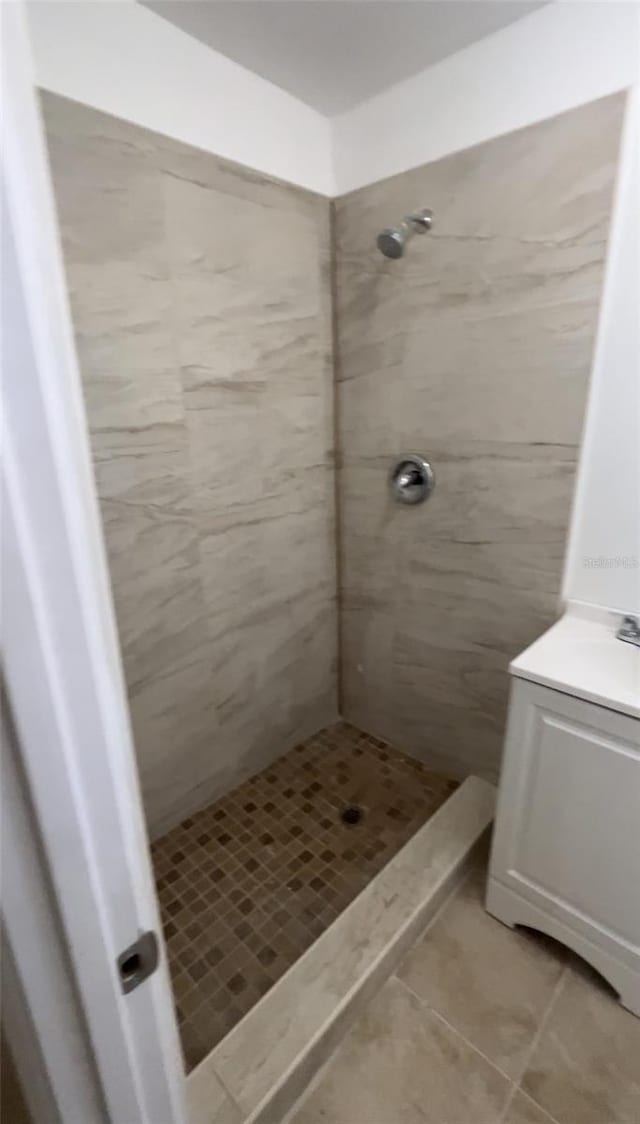 bathroom featuring tile patterned flooring and tiled shower