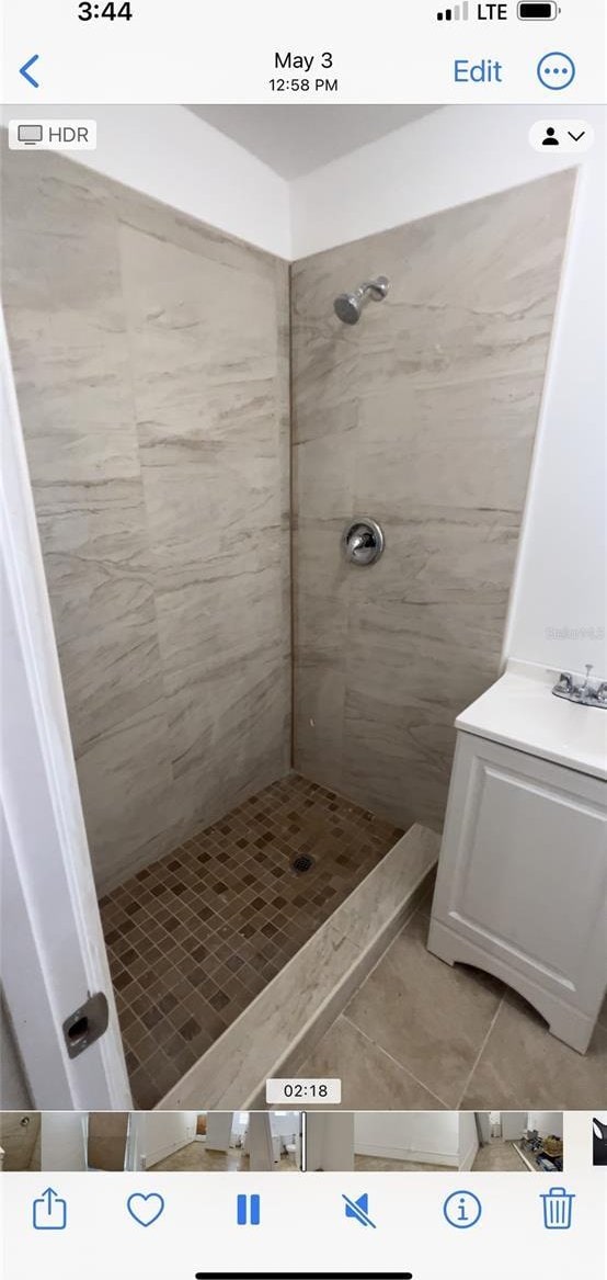 bathroom featuring tile patterned flooring and tiled shower