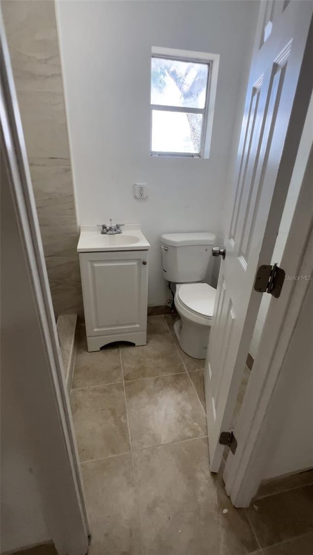 bathroom featuring tile patterned floors, vanity, and toilet