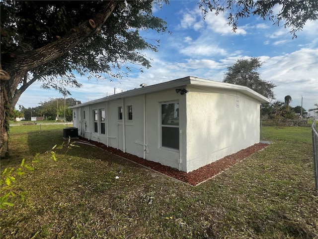 view of side of home featuring a lawn and central AC unit