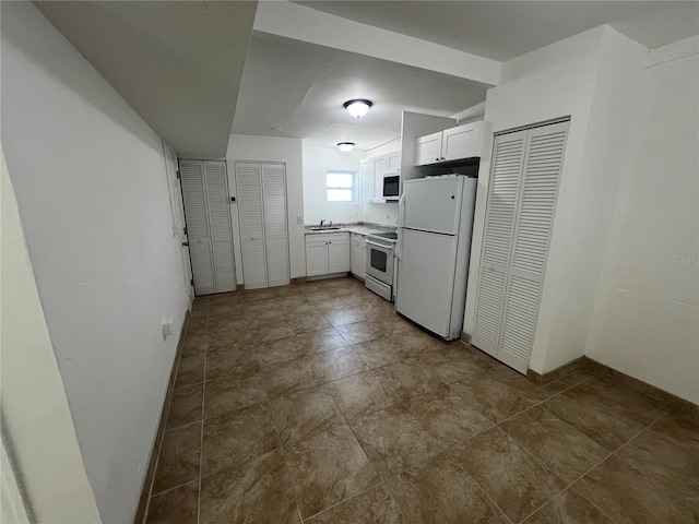 kitchen featuring electric range, white refrigerator, white cabinets, and sink