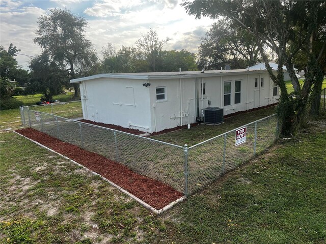 rear view of property with a yard and cooling unit