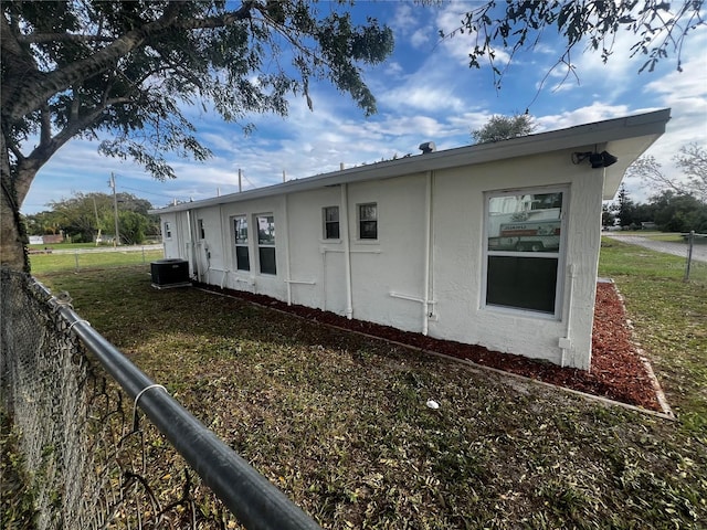 view of side of property with a yard and central AC unit