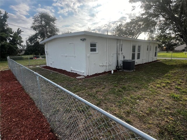 view of home's exterior featuring central AC and a lawn