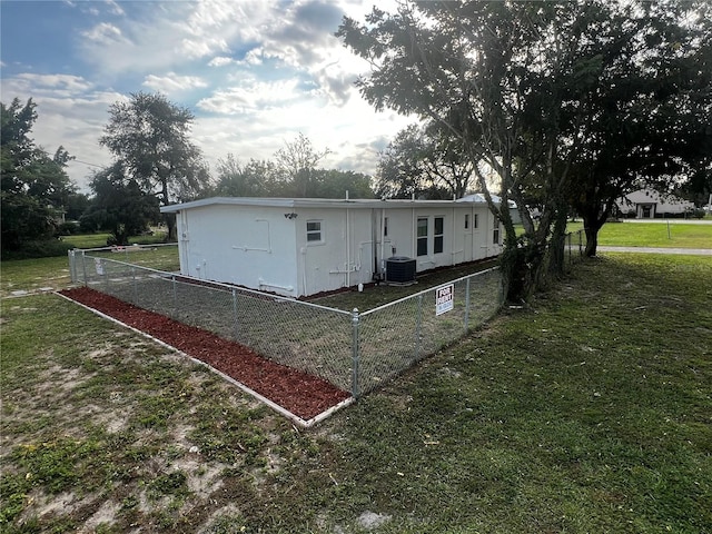 rear view of house featuring a yard and central air condition unit