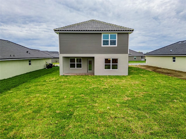 rear view of property featuring a yard