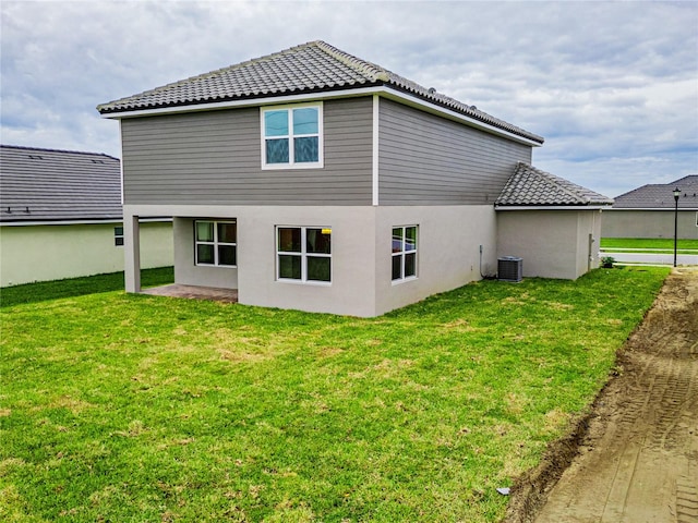 rear view of house featuring a patio, a yard, and central air condition unit