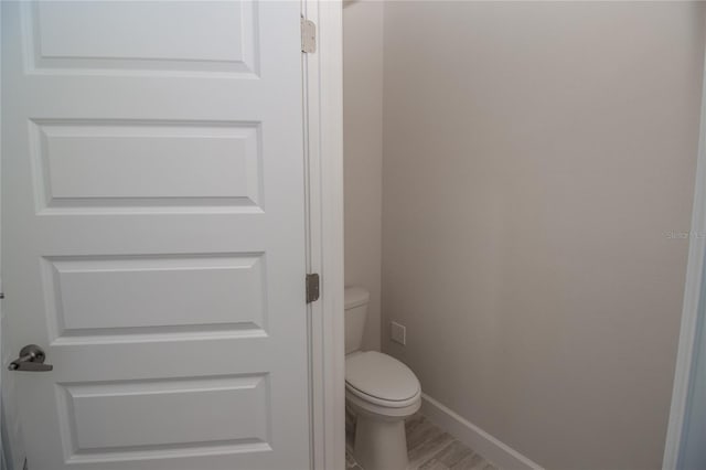 bathroom featuring hardwood / wood-style flooring and toilet