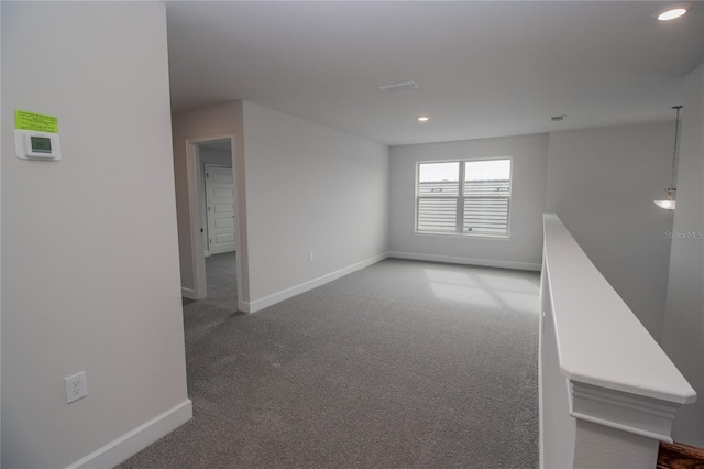 unfurnished room with dark carpet