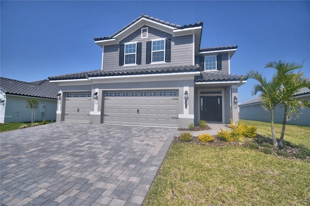 traditional-style house with a tiled roof, a front yard, driveway, and an attached garage