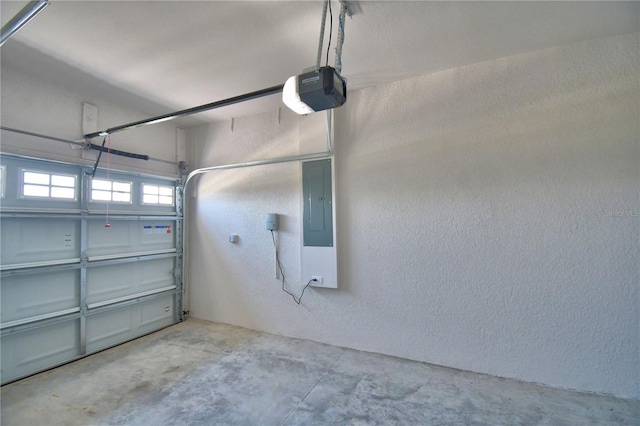 garage featuring a textured wall, electric panel, and a garage door opener