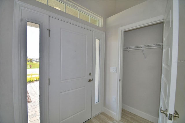 foyer entrance featuring baseboards and light wood-style floors