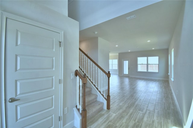 foyer entrance featuring visible vents, baseboards, stairs, recessed lighting, and light wood-type flooring