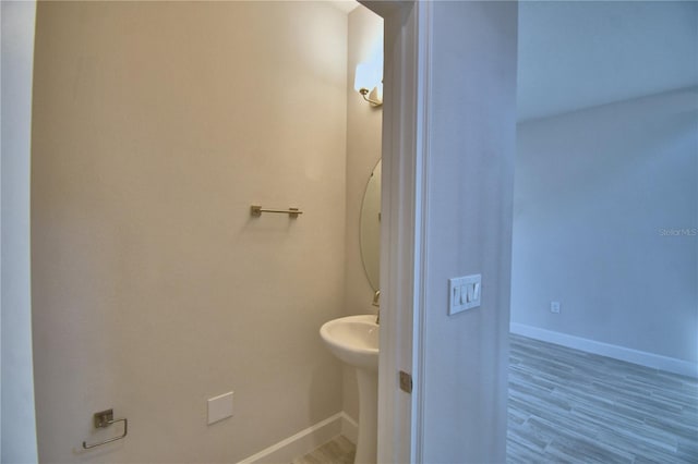 bathroom with baseboards and wood finished floors