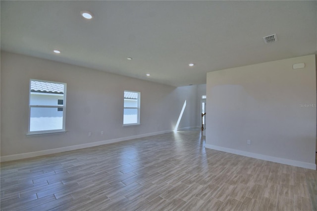 unfurnished room with baseboards, visible vents, recessed lighting, and light wood-type flooring