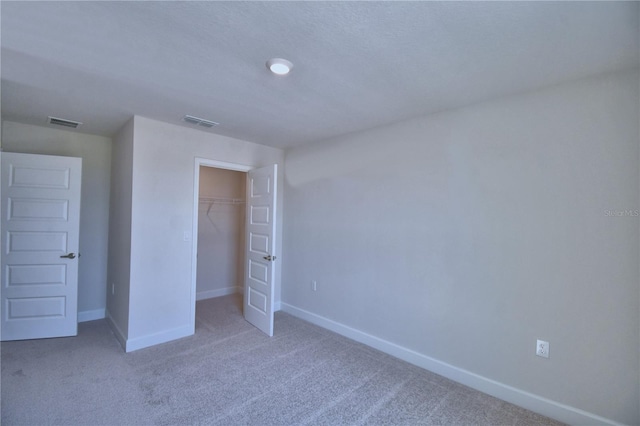 unfurnished bedroom featuring a closet, carpet, baseboards, and visible vents