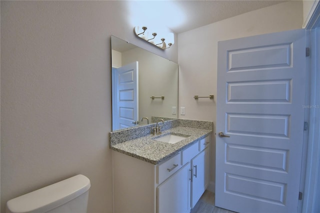 half bathroom featuring toilet and vanity