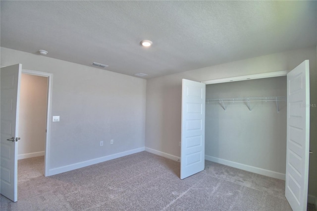 unfurnished bedroom with baseboards, visible vents, a closet, and carpet flooring