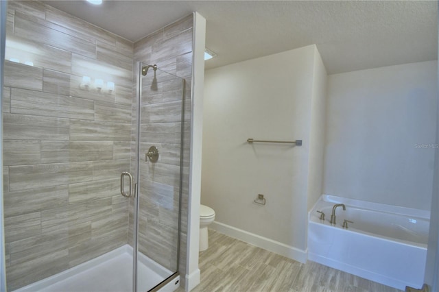 full bath with a stall shower, toilet, wood finished floors, a bath, and baseboards