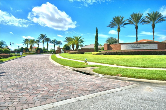 surrounding community with driveway and a yard