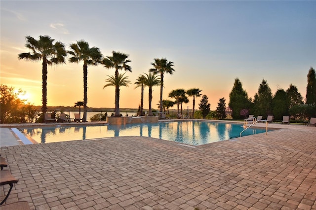 community pool with fence and a patio area
