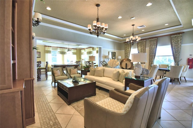 living room with a tray ceiling, visible vents, a chandelier, and light tile patterned floors