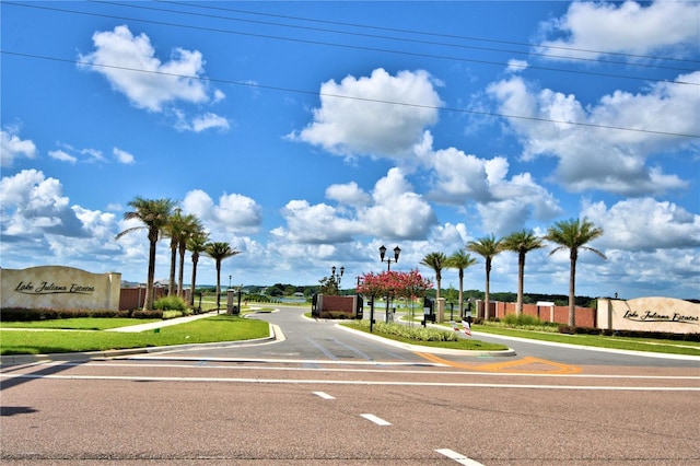 view of street with a gated entry and curbs