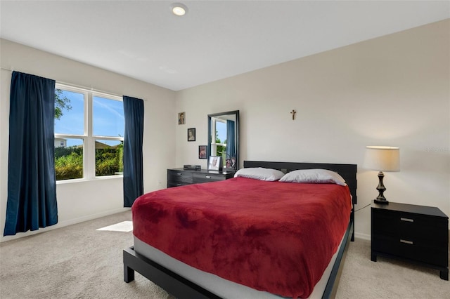 bedroom with baseboards and light colored carpet