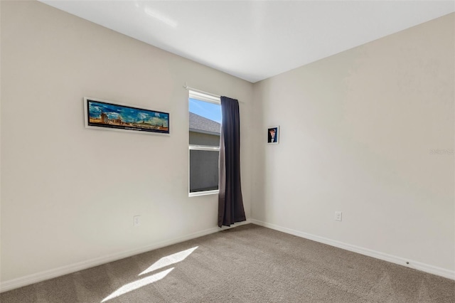 carpeted empty room with baseboards