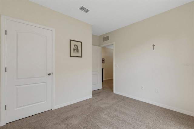 unfurnished bedroom with carpet floors, baseboards, and visible vents