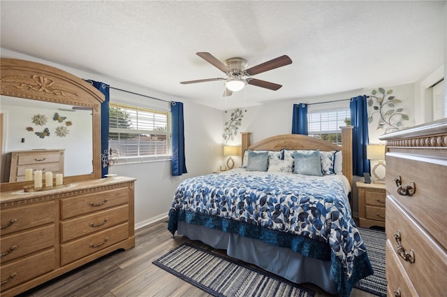 bedroom with ceiling fan, dark hardwood / wood-style floors, and a textured ceiling