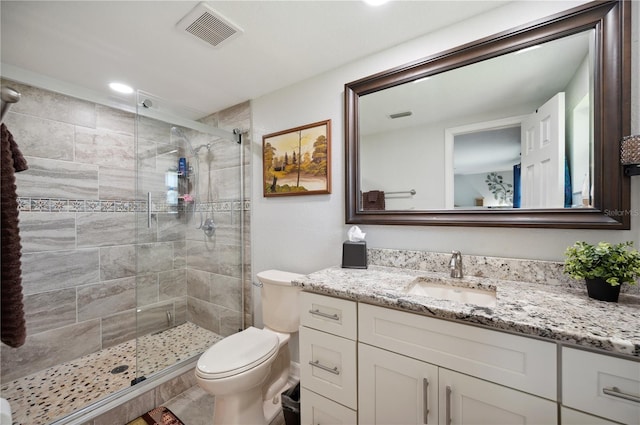 bathroom with an enclosed shower, vanity, and toilet