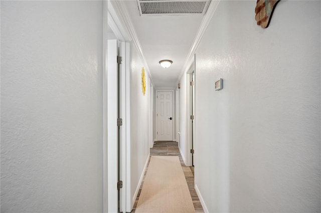 hallway featuring light hardwood / wood-style floors and crown molding