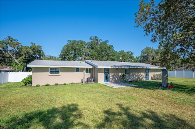 rear view of property featuring a yard and central air condition unit