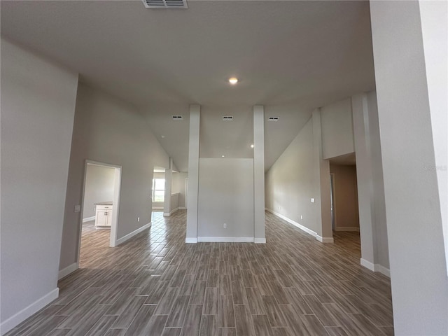 unfurnished room with high vaulted ceiling and dark hardwood / wood-style floors