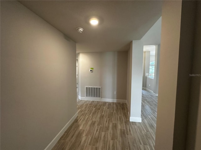 corridor with hardwood / wood-style floors