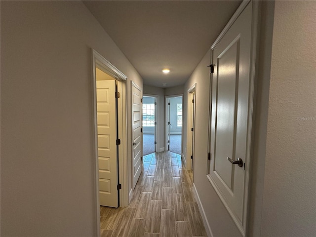 corridor with light hardwood / wood-style floors