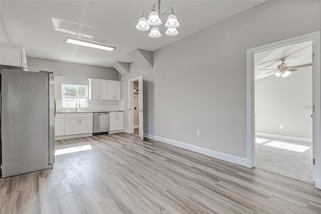 kitchen with decorative backsplash, appliances with stainless steel finishes, sink, decorative light fixtures, and white cabinetry