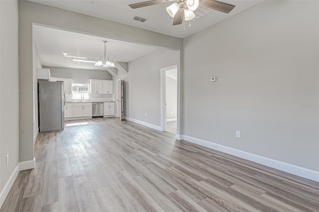 unfurnished living room with light hardwood / wood-style floors and ceiling fan with notable chandelier