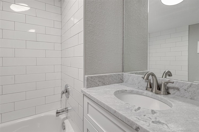 bathroom featuring vanity and tiled shower / bath