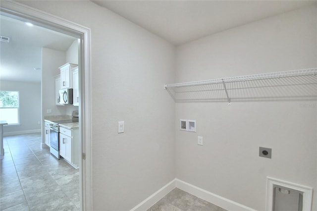 laundry room featuring electric dryer hookup, hookup for a washing machine, and light tile patterned floors