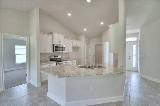 kitchen featuring kitchen peninsula, appliances with stainless steel finishes, sink, light tile patterned floors, and white cabinets